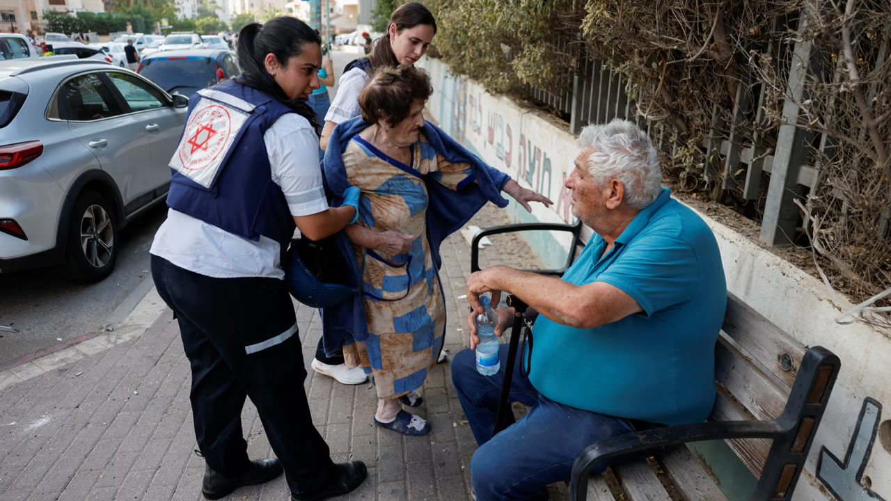 Emergency personnel assist a resident at an impacted residential site, following a missile attack from Iran on Israel, amid the Israel-Iran conflict in Be'er Sheva, Israel