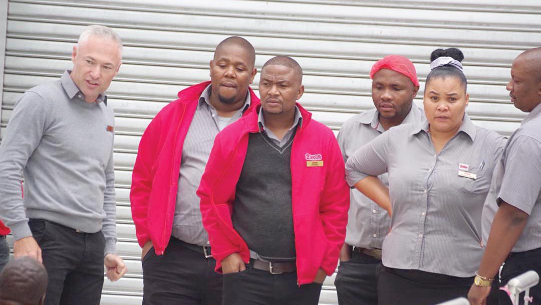 Dejected Boxer store Management waits outside the store after they failed to open yesterday following that they anticipated to open yesterday morning but due to compliance issues, they could not.
