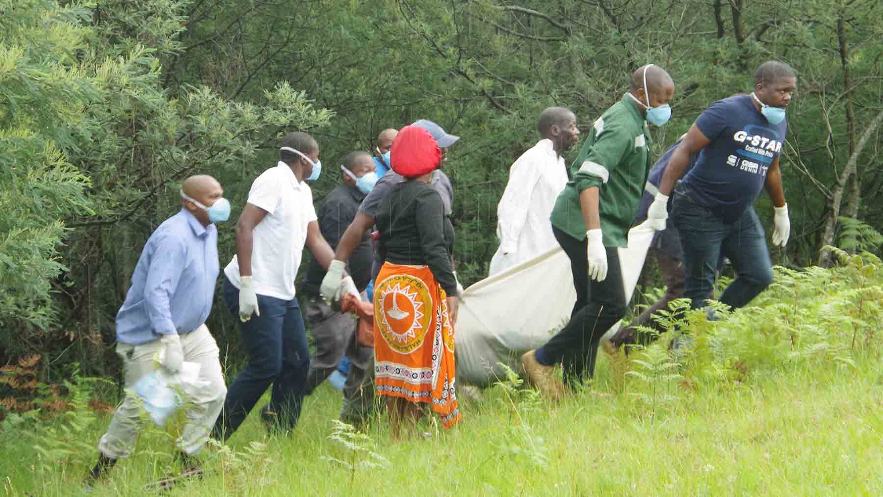 Police officers and members of the community leaving the forest with the lifeless body of Thulani Ginindza, who disappeared from home after the murder of his wife Princess ‘Nunu’ Johnson last Friday. The corpse was discovered by a team of community police members during a continued search.