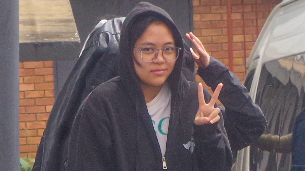 An accused person does a peace sign upon arrival at the Mbabane Magistrates Court.