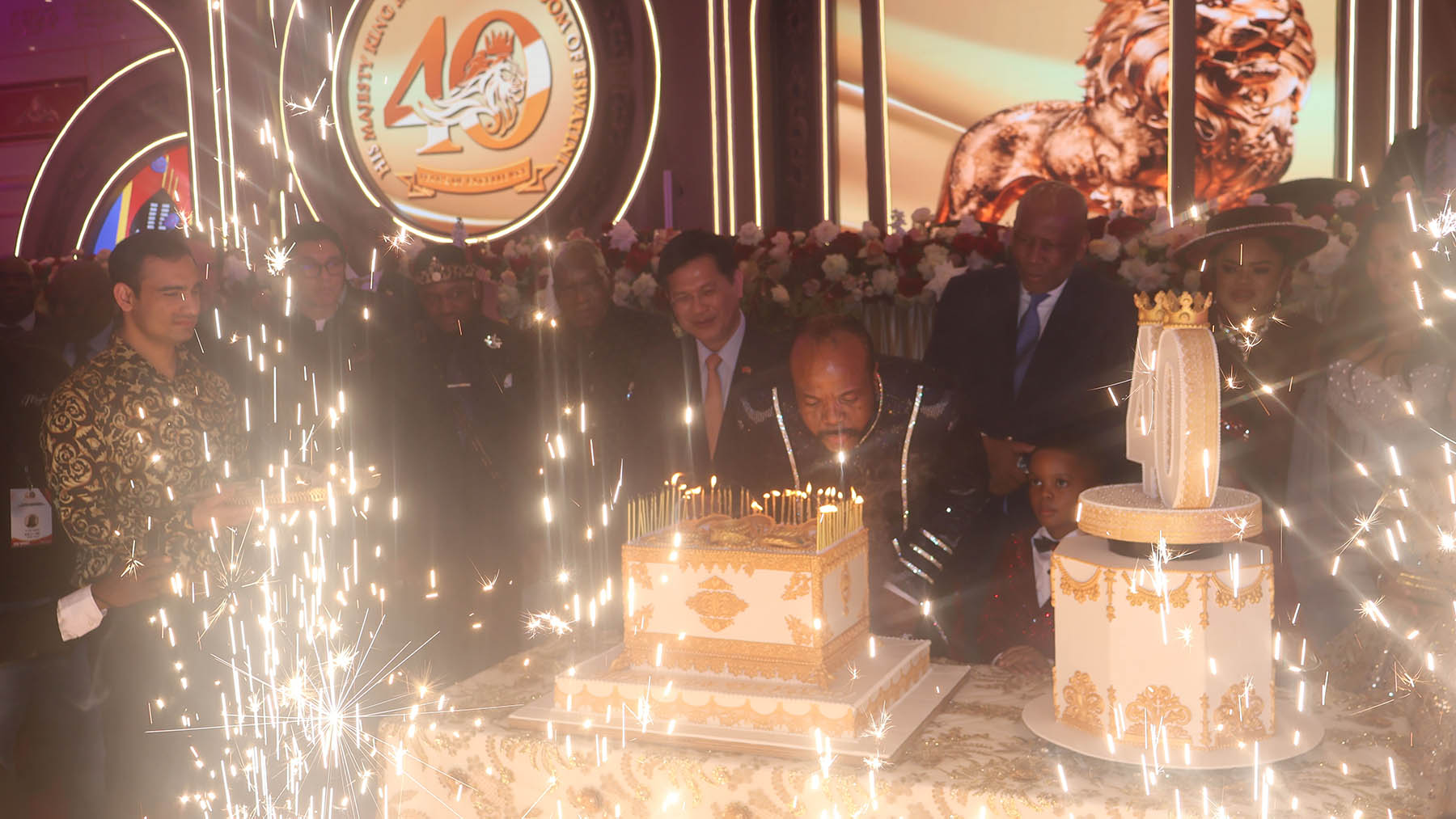 His Majesty the King blowing the candles on the cake.