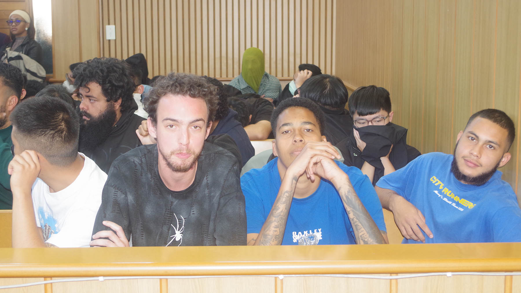 Some of the accused covered their faces while others remained relaxed.