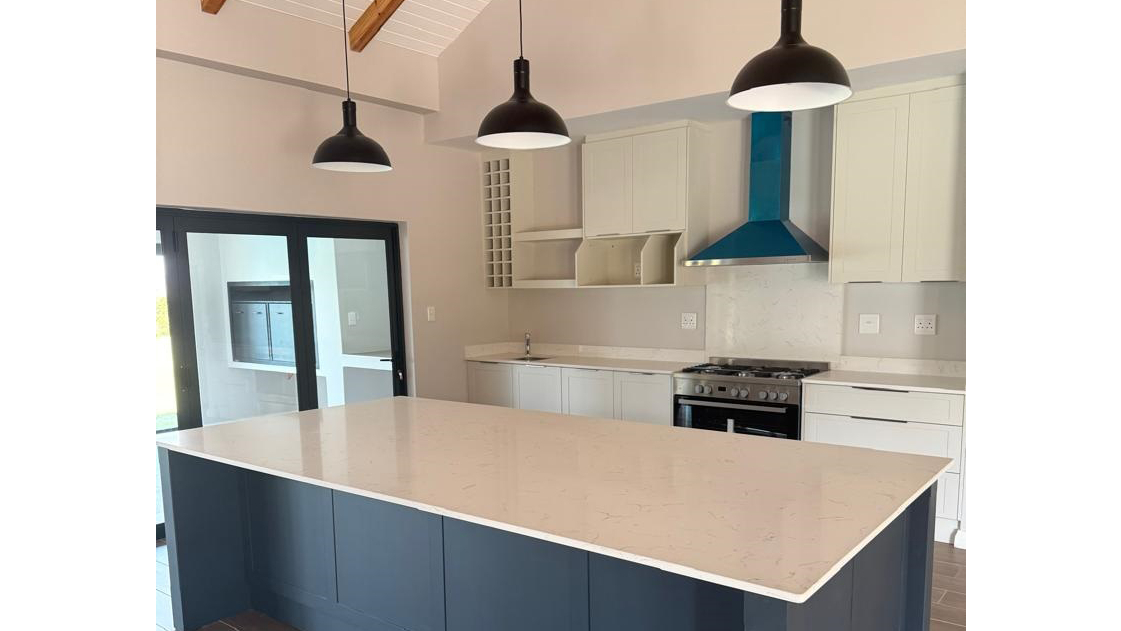 This modern fitted kitchen is complete with a gas stove and central island; a perfect blend of style and functionality.