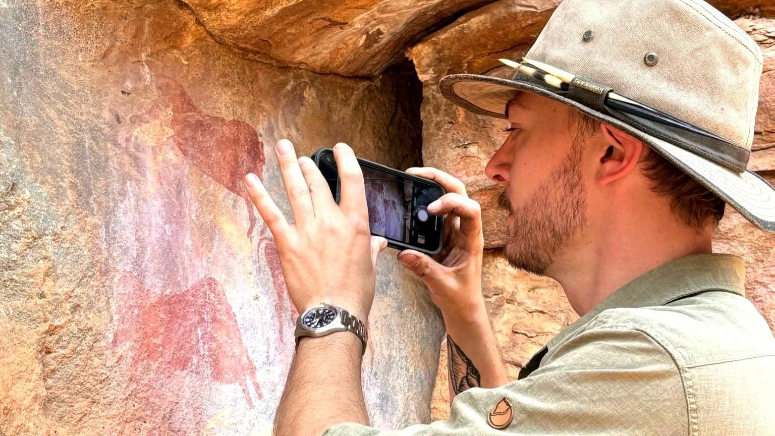 One tourist taking a picture of the rock paintings.