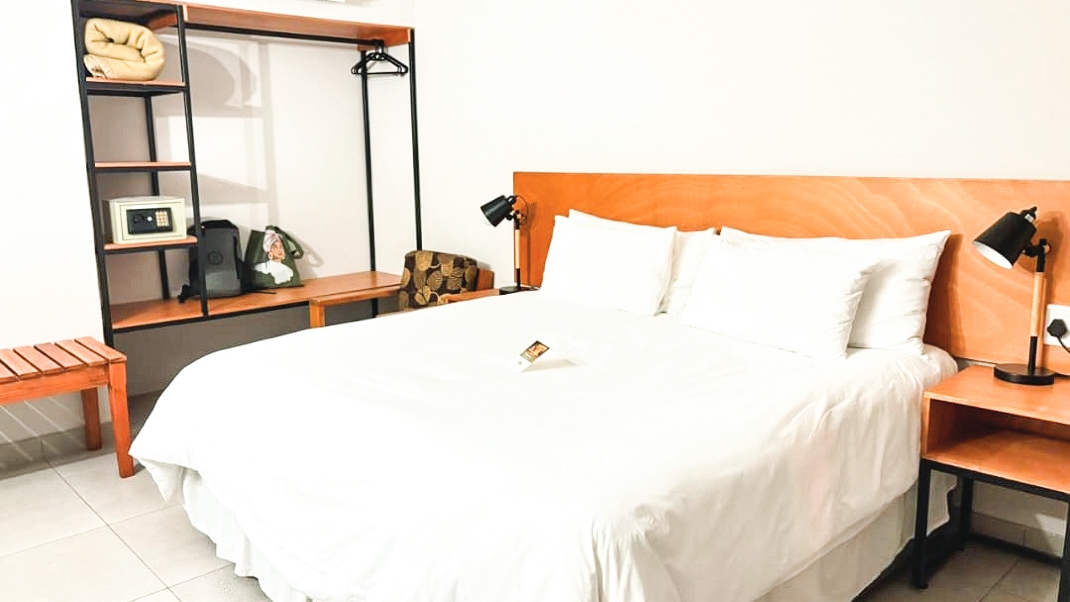 Swiping the room card unlocks a simple, cosy space bathed in white with rustic furniture.