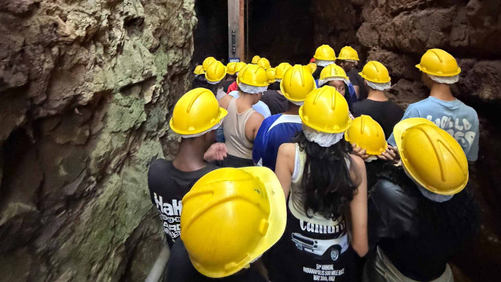 Learners donning mandatory safety helmets as they descend into the deep subterranean pathways of the Sterkfontein Caves within the Cradle of Humankind
