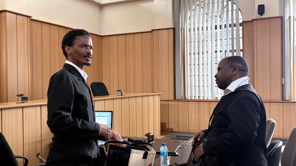 Xolani Mthethwa (L), who represents Mncina, and Senior Crown Counsel Sandile Mdluli is discussion after the adjournment.