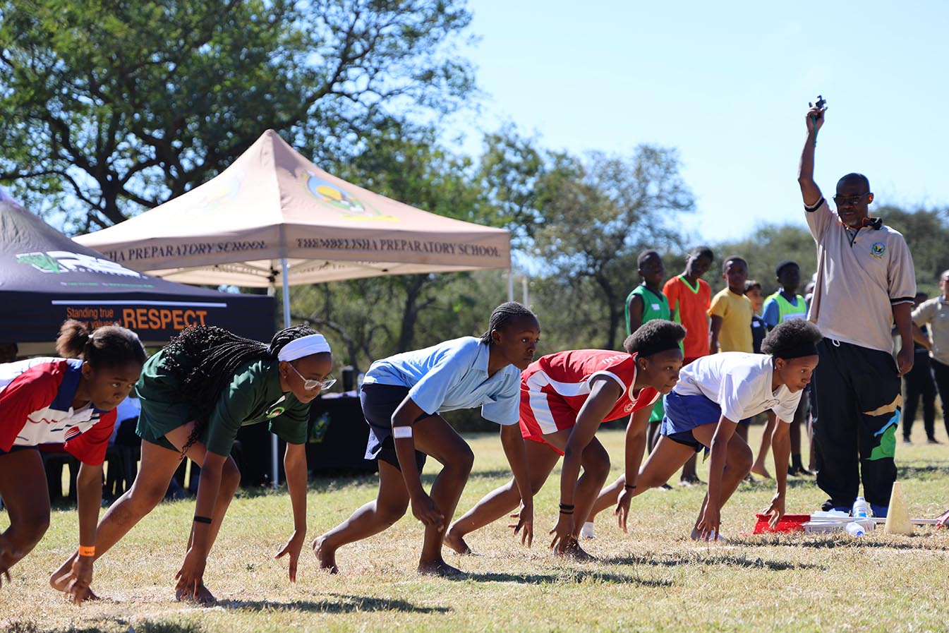 Athletes explode from the starting line during one of the sprint events at the 2026 ISASA Eswatini Primary Schools Interschools Athletics Championships.