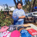 Founder of Namhla Crochets, Letsiwe Sithungo, displaying a custom handcrafted crochet hat alongside her vibrant collection of handmade wear at the Ezulwini Farmers Market. (Pics: Letsiwe)
