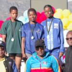 Girls’ 100m medallists (back row L-R) Eswatini’s Thandiwe Metiso, Yoliswa Simelane and Seychelles’ Aaliyah Nicette receive their medals from National Games LOC Chairman Zakhele Dlamini (R), Sports Council’s Dan Mavuso (C) and Eswatini National Olympic Committee Treasurer Zakhele Zulu. (Pic:Nimrod Hlophe)