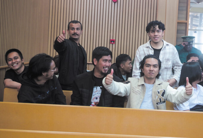 Foreign nationals celebrate after being sentenced to six months' imprisonment or a E500 fine on each of two counts for immigration and illegal employment offences.