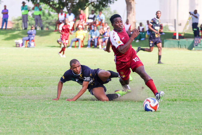 Manzini Wanderers' Mayibongwe ‘Mgadzanga’ Sacolo (R) gallops with the ball, leaving Ubombo Sugar defender Samkelo Ginindza behind. (File pic)
