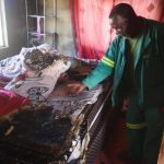 Phineas Mkhontfo pointing out to the damage caused by the mysterious fire.