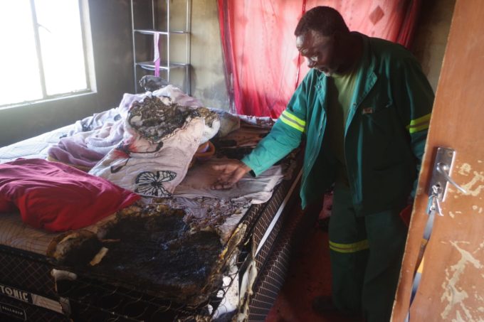 Phineas Mkhontfo pointing out to the damage caused by the mysterious fire.