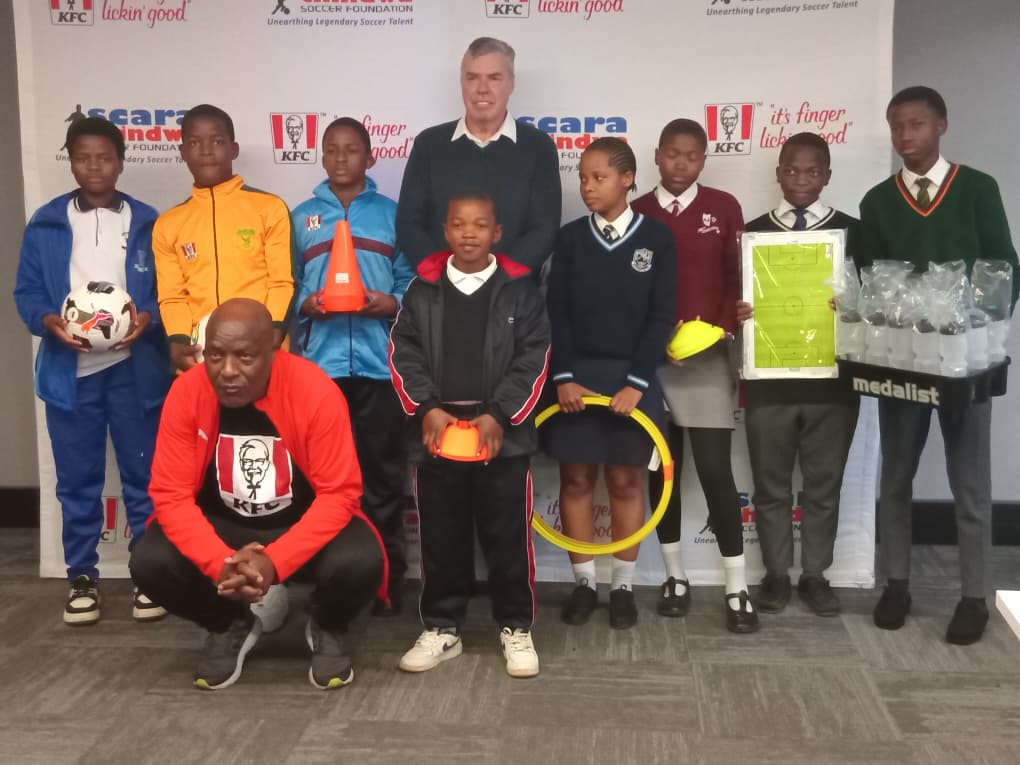 The legendary Absalom 'Scara' Thindwa squatting, the pupils and KFC CEO Nigel England after the presentation. (Pic: Times of Eswatini)