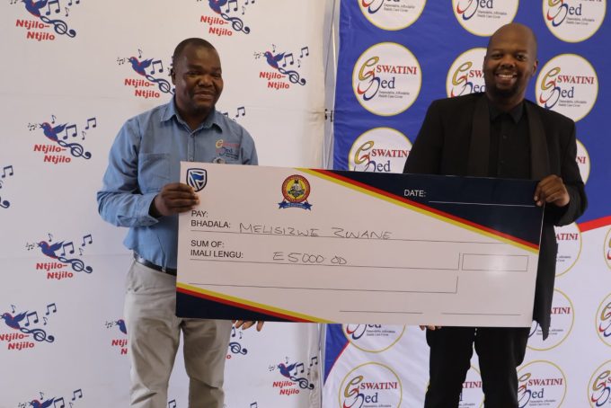 Melisizwe Zwane(R) receiving his E5 000 from Eswatini Med Principal Officer Sicalo Mkhonta